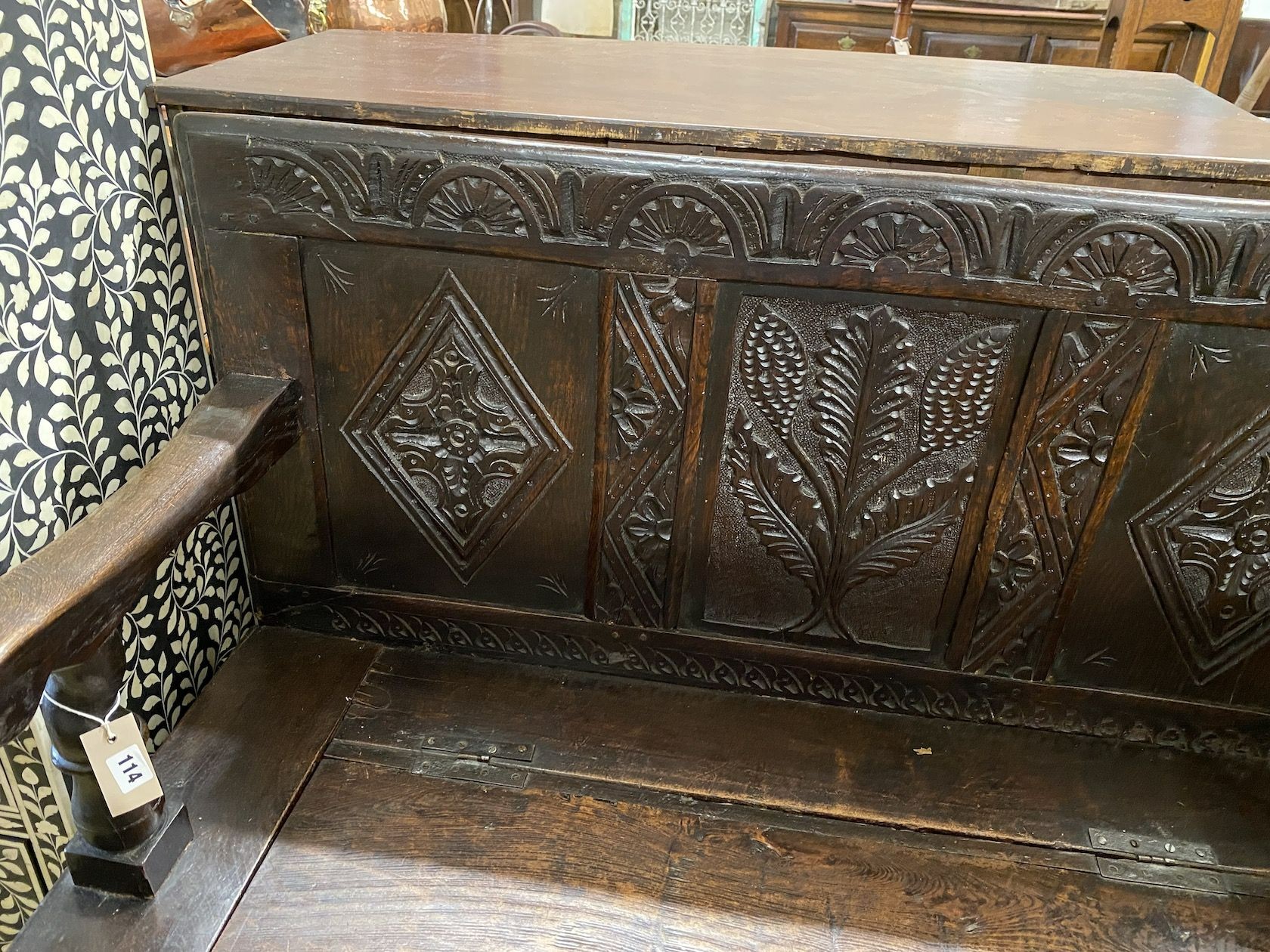 An 18th century carved oak box seat settle incorporating old timber, length 120cm, depth 44cm, height 101cm